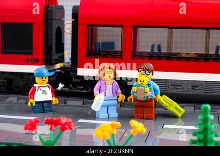 Tambow, Russische Föderation - 03. März 2021 Lego Familie steht auf dem Bahnsteig vor einem roten Zug Stockfoto