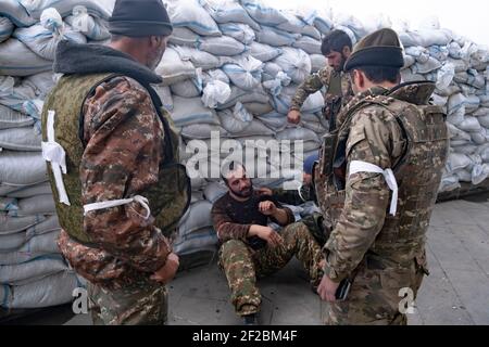 STEPANAKERT, BERG-KARABACH - 06. NOVEMBER: Mitglieder der Verteidigungsarmee warten am 06. November 2020 vor dem Hauptkrankenhaus von Stepanakert, der de facto Hauptstadt der selbsternannten Republik Arzakh oder Berg-Karabach, de jure Teil der Republik Aserbaidschan. Die Kämpfe zwischen Armenien und Aserbaidschan um Berg-Karabach, auch bekannt als die Republik Arzakh, brachen Ende September in einen sechswöchigen Krieg aus, in dem sich beide Länder gegenseitig der Provokation beschuldigten, die Tausende Tote hinterließ. Stockfoto