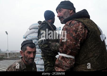 STEPANAKERT, BERG-KARABACH - 06. NOVEMBER: Mitglieder der Verteidigungsarmee warten am 06. November 2020 vor dem Hauptkrankenhaus von Stepanakert, der de facto Hauptstadt der selbsternannten Republik Arzakh oder Berg-Karabach, de jure Teil der Republik Aserbaidschan. Die Kämpfe zwischen Armenien und Aserbaidschan um Berg-Karabach, auch bekannt als die Republik Arzakh, brachen Ende September in einen sechswöchigen Krieg aus, in dem sich beide Länder gegenseitig der Provokation beschuldigten, die Tausende Tote hinterließ. Stockfoto