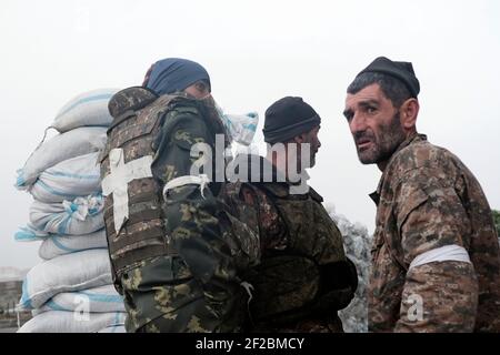 STEPANAKERT, BERG-KARABACH - 06. NOVEMBER: Mitglieder der Verteidigungsarmee warten am 06. November 2020 vor dem Hauptkrankenhaus von Stepanakert, der de facto Hauptstadt der selbsternannten Republik Arzakh oder Berg-Karabach, de jure Teil der Republik Aserbaidschan. Die Kämpfe zwischen Armenien und Aserbaidschan um Berg-Karabach, auch bekannt als die Republik Arzakh, brachen Ende September in einen sechswöchigen Krieg aus, in dem sich beide Länder gegenseitig der Provokation beschuldigten, die Tausende Tote hinterließ. Stockfoto