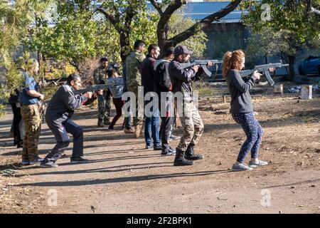 JEREWAN, ARMENIEN – NOVEMBER 09: Armenische Zivilisten nutzen Holzschnitzelwaffen während eines Anfängertrainings für Kampf und Überleben, der von Ausbildern der VoMA Survival School durchgeführt wird, die von Veteranen eines früheren Krieges in Berg-Karabach gegründet wurde, mit dem staatlichen Mandat, neue freiwillige Rekruten militärisch auszubilden, die Armenien gegen jede ausländische Invasion verteidigen möchten. Der Kurs findet in einem verlassenen Innenhof in einem Vorort von Jerewan statt, der als militärisches Trainingszentrum nachgerüstet wurde. Armenien. Stockfoto