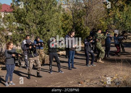 JEREWAN, ARMENIEN – NOVEMBER 09: Armenische Zivilisten nutzen Holzschnitzelwaffen während eines Anfängertrainings für Kampf und Überleben, der von Ausbildern der VoMA Survival School durchgeführt wird, die von Veteranen eines früheren Krieges in Berg-Karabach gegründet wurde, mit dem staatlichen Mandat, neue freiwillige Rekruten militärisch auszubilden, die Armenien gegen jede ausländische Invasion verteidigen möchten. Der Kurs findet in einem verlassenen Innenhof in einem Vorort von Jerewan statt, der als militärisches Trainingszentrum nachgerüstet wurde. Armenien. Stockfoto