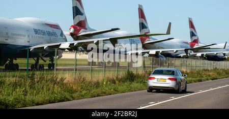 Kemble, Gloucestershire, England, Großbritannien. 2020. Eine Limousine fährt an Flugzeugen des Typs BA 747 vorbei, die wegen der Covid-Epidemie zum Zerlegen am Flughafen Cotswold anstanden. Stockfoto