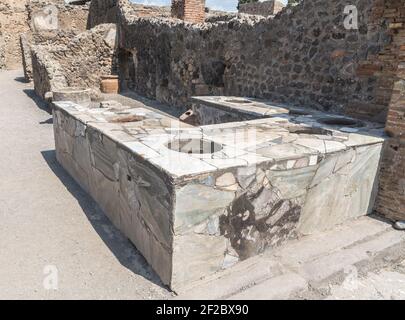 Thermopolium oder Taberna (Köchin) in der antiken römischen Stätte Pompeji, in der Nähe von Neapel. Sie wurde durch den Ausbruch des Vesuv völlig zerstört. Stockfoto