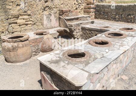 Thermopolium oder Taberna (Kochwerkstatt) in Ercolano - Herculaneum, alte römische Stadt, die durch den Ausbruch des Vesuv oder Vesuv Vulkan zerstört wurde Stockfoto