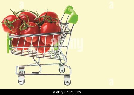 Nahaufnahme der roten Tomaten im Warenkorb auf gelbem Hintergrund isoliert. Stockfoto
