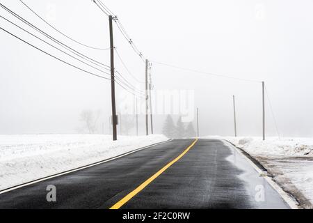 Eine Straße im ländlichen Templeton, Massachusetts an einem nebligen Wintertag Stockfoto