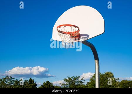 Basketballkorb auf blauem Himmel Hintergrund im Schulhof Stockfoto