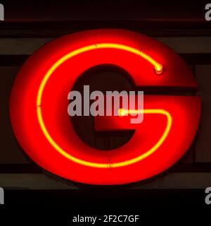 Rot glühender Neonbuchstabe G in der Nacht Stockfoto