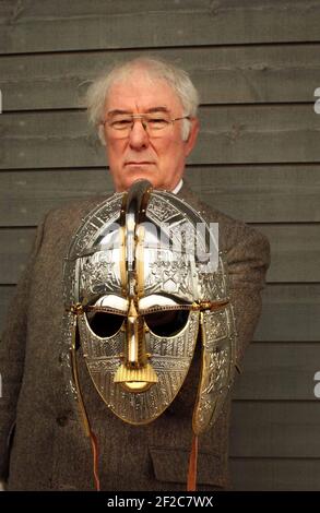 SEAMUS HEANEY AUTOR DER GEFEIERTEN ÜBERSETZUNG VON BEOWULF HÄLT EINE REPLIK DES SUTTON HOO HELMS BEI DER ERÖFFNUNG EINES NEUEN AUSSTELLUNGSZENTRUMS AM SUTTON HOO STANDORT, DIE SCHÄTZE DES BRITISH MUSEUM AUSGELIEHEN ENTHÄLT. 13/3/02 PILSTON Stockfoto