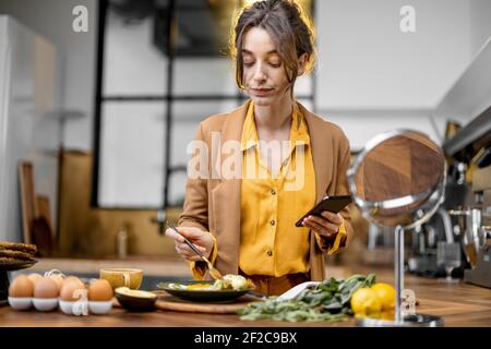 Pingelige junge Geschäftsfrau in Eile, um am Morgen zu arbeiten, trinken Kaffee und aplying Make-up auf dem Weg Stockfoto