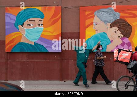 Santiago, Metropolitana, Chile. März 2021, 11th. Ein Krankenhauspersonal geht vor einige Gemälde, die zu Ehren des Gesundheitspersonals angefertigt wurden. Quelle: Matias Basualdo/ZUMA Wire/Alamy Live News Stockfoto