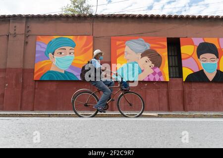 Santiago, Metropolitana, Chile. März 2021, 11th. Ein Radfahrer kommt vor den Gemälden, die zu Ehren des Gesundheitspersonals angefertigt wurden. Quelle: Matias Basualdo/ZUMA Wire/Alamy Live News Stockfoto