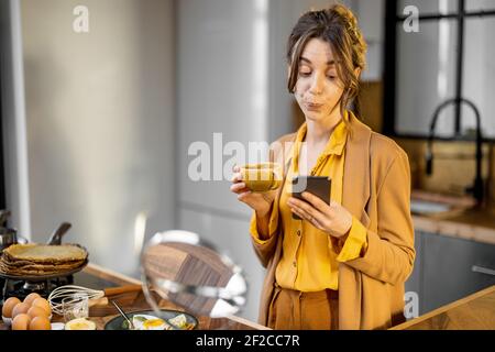 Pingelige junge Geschäftsfrau in Eile, um am Morgen zu arbeiten, Kaffee trinken und telefonieren unterwegs Stockfoto