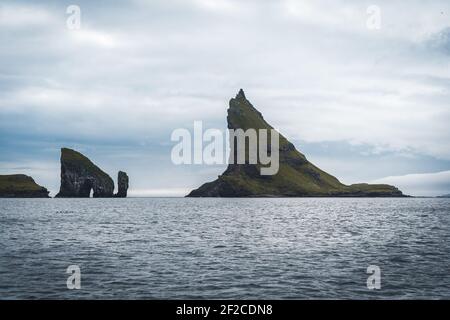 Nahaufnahme der berühmten Drangarnitr Klippe mit den Tindholmur Inseln in Der Hintergrund wurde während der morgendlichen Wanderung im Frühjahr aufgenommen Färöische Küste Stockfoto