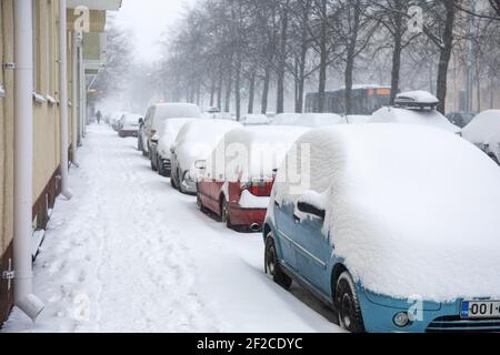 Schneebedeckte Autos auf Huopalahdente im Munkkiniemi-Viertel von Helsinki, Finnland Stockfoto