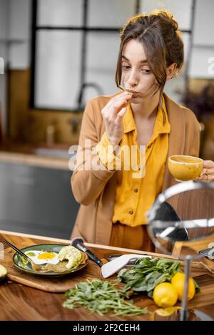 Pingelige junge Geschäftsfrau in Eile, um am Morgen zu arbeiten, trinken Kaffee und aplying Make-up auf dem Weg Stockfoto