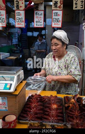 Frau, die Oktopus auf dem Fischmarkt in Akashi, Präfektur Hyogo, Japan verkauft. . Stockfoto