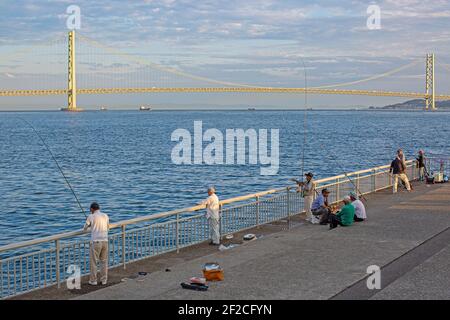 Angler im Hintergrund der Akashi Kaikyo Brücke am Sommermorgen.Akashi, Präfektur Hyogo, Japan. Stockfoto