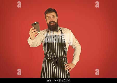 Reife qualifizierte Barista in Schürze. Am besten nehmen Kaffee. Kaffee zu gehen. Bartender mit Pappbecher. Guten Morgen Kaffee. Frische energetische Getränk. Chef Mann empfehlen Getränk. Stockfoto