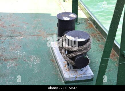 Verrostete Anlegestelle mit Schiffsseilen auf einer alten Fähre. Poller mit Anlegestellen auf dem Schiff. Stockfoto