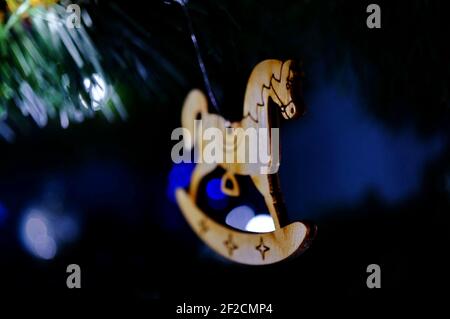 Hölzerne Weihnachtsdekoration in Form eines kleinen Schaukelns Pferd auf dunklem Hintergrund Stockfoto