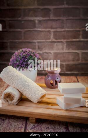 Schöne Spa-Komposition mit Naturseifen mit Duftkerzen und Bad-Accessoires in einem romantischen Rahmen für ein Reinigungskonzept. Stockfoto