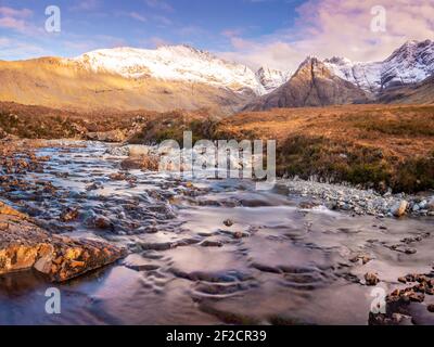 Wasserfall zwischen scharfkantigen Felsen, die Fairy Pools auf der Isle of Skye, atemberaubende kristallklare Wasserfälle zwischen felsigen Bergen Stockfoto
