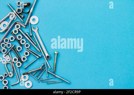 Schrauben, Muttern, Schraubenschlüssel und andere Bauwerkzeuge auf blauem Hintergrund. Vatertag Konzept. Flach liegend. Draufsicht. Copyspace Stockfoto