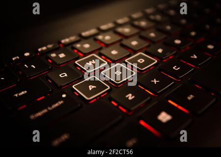Schwarze Laptop-Tastatur mit verschiedenen WASD-Tasten und roter Hintergrundbeleuchtung Stockfoto