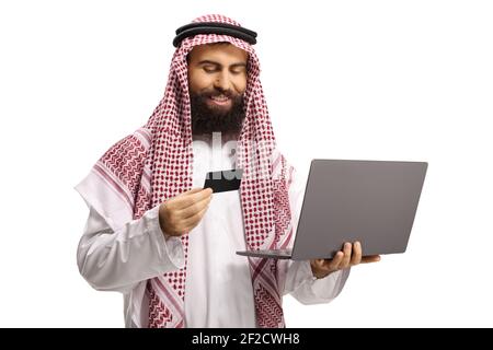 Saudi-arabischer Mann mit Kreditkarte und Laptop Computer auf weißem Hintergrund isoliert Stockfoto