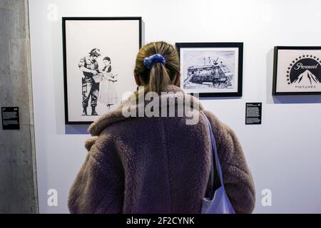 Eine Frau bewundert die Grafiken "Stop and Search", "Police Riot Van" und "Paranoid Pictures" während der Ausstellung.in der Galerie Koneser Centrum Praskie "The Art of Banksy. Ohne Grenzen“ ist die erste Ausstellung in Polen als große Präsentation der Werke dieses geheimnisvollen Künstlers. Es präsentiert über 100 Werke, Originalexponate, aber auch Arbeiten in Form von Fotografien, Skulpturen und vielen anderen. Darüber hinaus werden einige der Exponate mit seiner eigenen Technik rekonstruiert – Vorlagen, die speziell für diese Ausstellung erstellt wurden. WIE die meisten von Banksy's Ausstellung ist auch diese nicht von der autorisiert Stockfoto