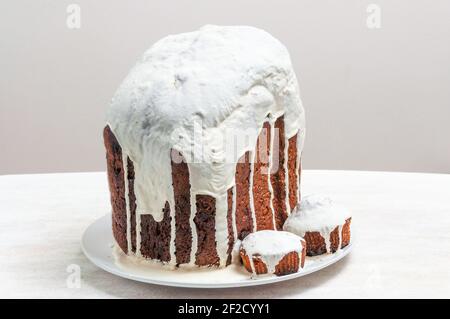 Hausgemachte handgemachte Osterkuchen, bedeckt mit weißer Glasur, auf einem Teller auf weißem Hintergrund. Stockfoto