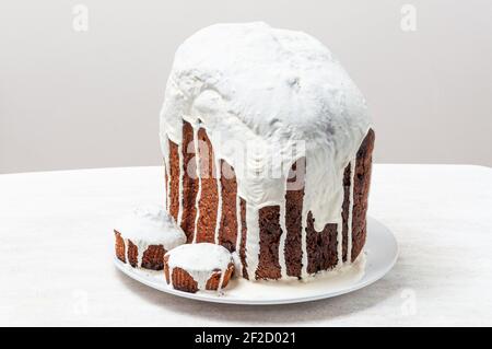Hausgemachte handgemachte Osterkuchen, bedeckt mit weißer Glasur, auf einem Teller auf weißem Hintergrund. Stockfoto