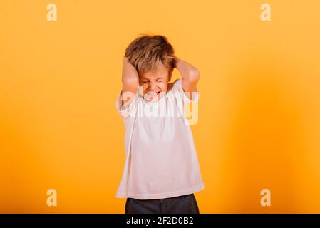 Portrait von glücklichen kleinen Jungen auf gelbem Hintergrund im Studio Stockfoto