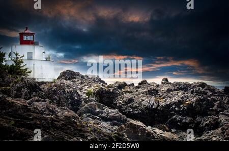 Ein traditioneller Leuchtturm an der felsigen Westküste von Vancouver Island in der Nähe des Pacific Rim National Park unter einem dramatischen Himmel. Stockfoto