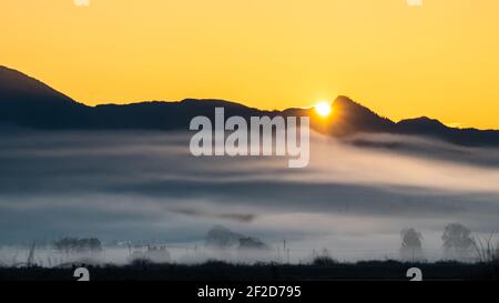 Gelber Sonnenaufgang über den Cascades Mountains mit Nebel Das Skagit-Tal des westlichen Staates Washington Stockfoto