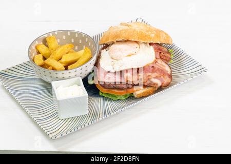 Spezieller Burger mit Speck und Spiegelei, pommes Frites und Mayo Dip Stockfoto