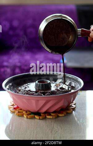 Gießen Schokolade Sahne auf dem Kuchen . Nahaufnahme. Selektiver Fokus. Stockfoto