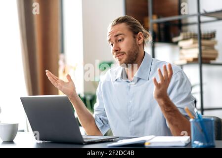 Verärgert kaukasischen beschäftigt Business guy Blick auf einen Laptop in Verwirrung, erhielt unerwartete Nachrichten, gescheitert ein Geschäft, schreit, gestikuliert mit Händen, Sitzen am Schreibtisch im Heimbüro Stockfoto