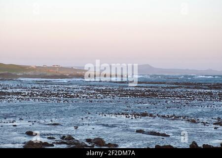 Sonnenuntergang über einer Bucht voller Seetang in Gansbaai, Südafrika Stockfoto