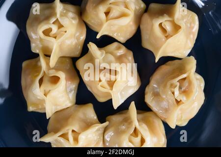 Traditionelles hausgemachtes usbekisches Gericht, Manti, gedünstete Knödel auf marineblauer Platte oberhalb der Ansicht Stockfoto