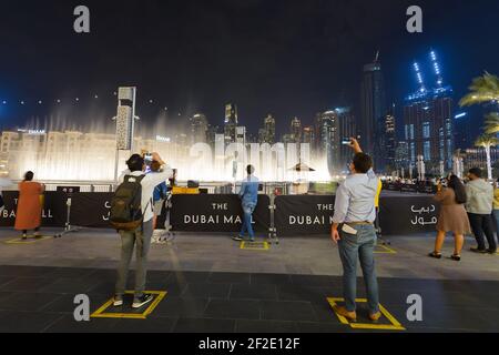 Die Dubai Fountain Show mit Grundzeichen für soziale Distanzierung für Touristen, die während einer Pandemie reisen. Touristenattraktion während der COVID-19 in Dubai. Stockfoto