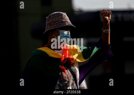 Eine Frau trägt eine Regenbogenflagge als Mitglieder einer LGBT-Gruppe (Lesbians Gays Bisexual Transgender) gegen die frühe Freilassung des US-Soldaten Joseph Scott Pemberton am Boy Scout Circle in Quezon City, Metro Manila, Philippinen protestieren. Stockfoto