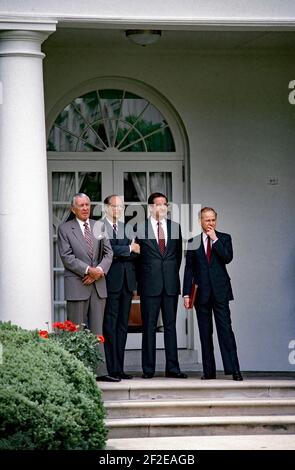 Washington, DC. USA, 13. Mai 1986L-R Stabschef des Weißen Hauses Donald Regan, White House Aide W. Dennis Thomas, Kommunikationsdirektor des Weißen Hauses Patrick J. Buchanan, nicht identifizierter WH-Helfer, Als Präsident Ronald Reagan die Eröffnungsrede an die Oberklasse der John A. Holmes High School im Rosengarten des Weißen Hauses übergibt, nahm Reagan nach seiner Rede Fragen aus der Gruppe an.Credit: Mark Reinstein / MediaPunch Stockfoto