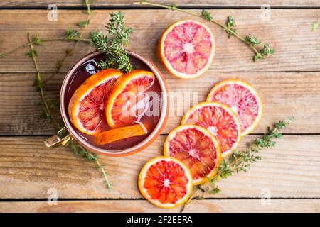 Cocktail aus roten Orangen in Kupferkrug (Variante des Moskauer Maultieres) auf dem Holzhintergrund. Selektiver Fokus. Geringe Schärfentiefe. Stockfoto