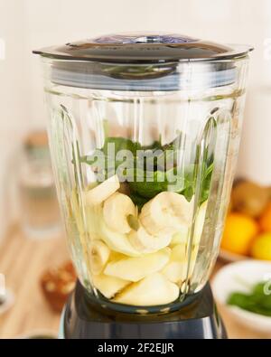 Morgen veganes Frühstück im Mixer, Herstellung Smoothies für Detox und richtige Ernährung, vertikal Stockfoto