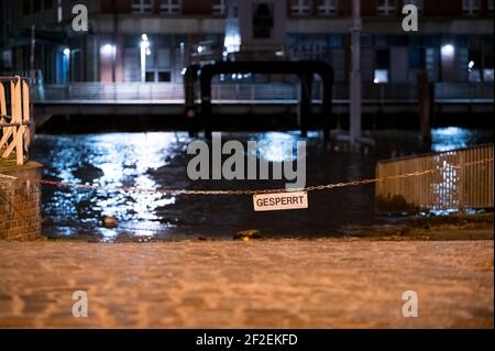 Hamburg, Deutschland. März 2021, 12th. Ein von der Elbe überfluteter Parkplatz ist geschlossen. Nach einem stürmischen Donnerstag sollte sich die Lage an der Wetterfront in Deutschland vorerst etwas entspannen. Obwohl es heute in weiten Teilen des Landes windig bis stürmisch bleiben soll, aber nicht so stark wie am Vortag, sagte ein Sprecher des Deutschen Wetterdienstes (DWD). Quelle: Jonas Walzberg/dpa/Alamy Live News Stockfoto