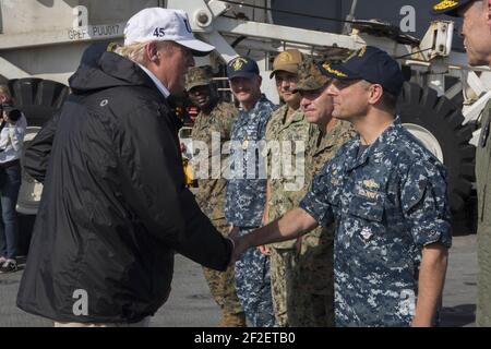 Präsident Donald Trump schüttelt sich bei einem Besuch des Schiffes in Puerto Rico die Hände mit Kapitän David Guluzian. (23643221988). Stockfoto