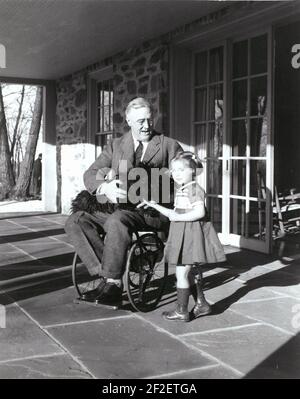 Präsident Franklin Delano Roosevelt in seinem Rollstuhl mit Fala und Ruthie Bie in Top Cottage. Stockfoto